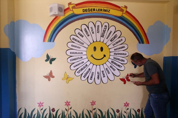 Öğrenciler için gönüllü olarak sınıf duvarlarını renklendiriyor